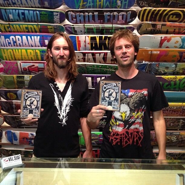 Two California surfer-dude Val Surf employees each holding up an award