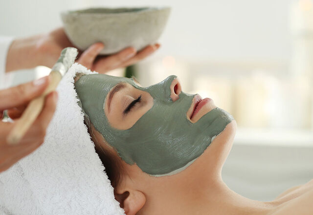 Woman having cosmetics applied to face