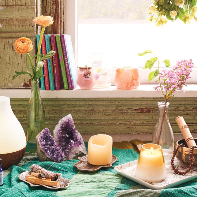 Various items on a teal cloth with a flower in a small vase.