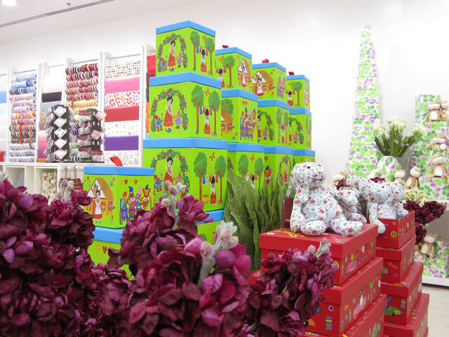 A large assortment of very colorful giftbags and giftwraps inside a white, well-lit store