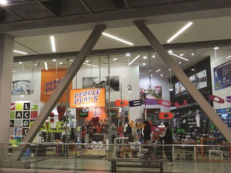 Exterior view of a large People Play's store with logo hanging from the cieling