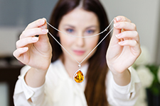 woman holding pu an amber pendant